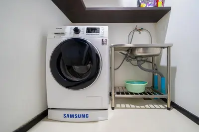 a washing machine in a room with a sink at Tropical retreat-pool villa at Oxygen Bangtao in Ban Thalat Choeng Thale