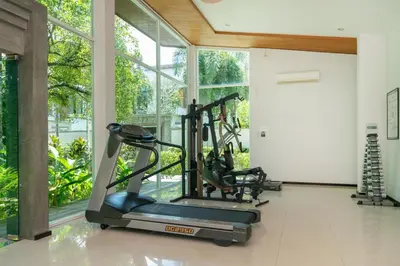 a gym with a treadmill and a large window at Tropical retreat-pool villa at Oxygen Bangtao in Ban Thalat Choeng Thale