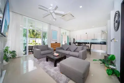 a living room with a couch and a table at Tropical retreat-pool villa at Oxygen Bangtao in Ban Thalat Choeng Thale