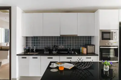 a kitchen with white cabinets and a black counter top at 2BR Penthouse with Private Pool Rooftop Absolute Twin Sands 5404 in Patong Beach