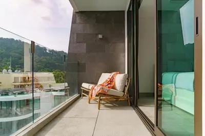 a balcony with a chair and a bed at 2BR Penthouse with Private Pool Rooftop Absolute Twin Sands 5404 in Patong Beach