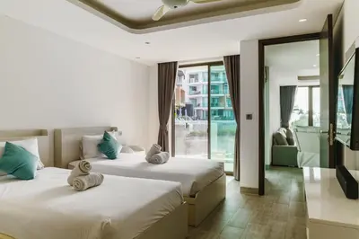 two beds in a hotel room with a balcony at 2BR Penthouse with Private Pool Rooftop Absolute Twin Sands 5404 in Patong Beach