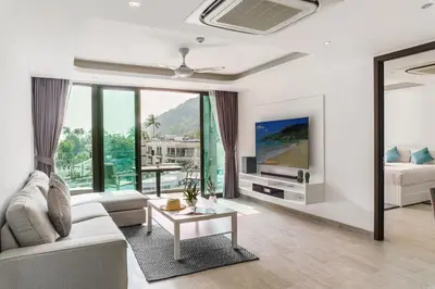 a living room with a couch and a tv at 2BR Penthouse with Private Pool Rooftop Absolute Twin Sands 5404 in Patong Beach