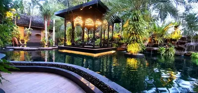 a garden with a pond in front of a house at Villa Habeebee in Ao Nang Beach