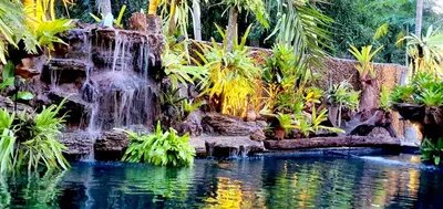 a waterfall in a garden with a pool of water at Villa Habeebee in Ao Nang Beach