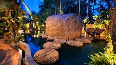 a garden with a pond with stools in the water at Villa Habeebee in Ao Nang Beach
