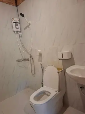 a bathroom with a shower and a toilet and a sink at Fadel Bungalow ฟาดิลบังกะโล in Ban Lo Pa Ret