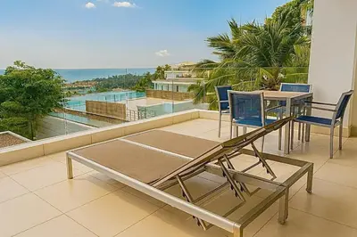 a balcony with a table and chairs and a view of the ocean at The Seaview Kata in Kata Beach