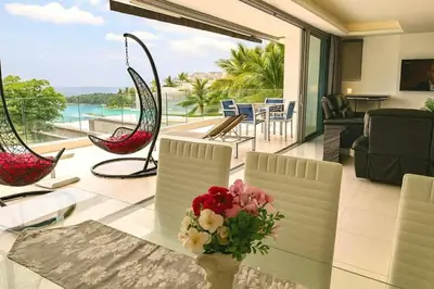 a living room with a vase of flowers on a table at The Seaview Kata in Kata Beach