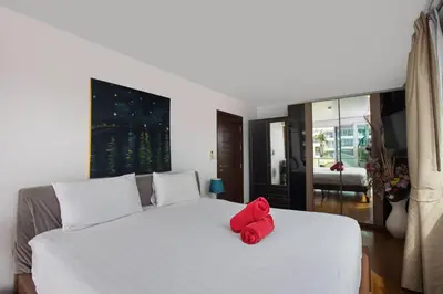a red stuffed animal sitting on top of a white bed at Modern 2BR Condo at Karon Butterfly Phuket in Karon Beach