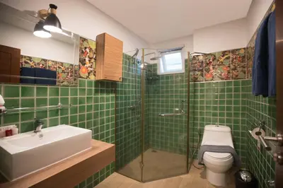 a green tiled bathroom with a sink and a shower at Modern 2BR Condo at Karon Butterfly Phuket in Karon Beach