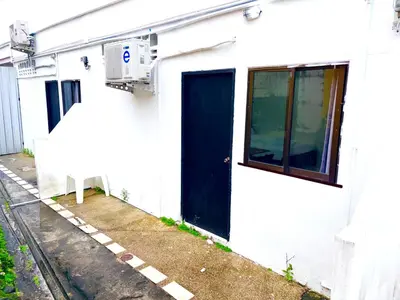 a white building with a blue door on the side of it at Patong Canal Villa 103 in Patong Beach