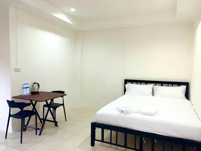 a bedroom with a bed and a table with chairs at Patong Canal Villa 103 in Patong Beach