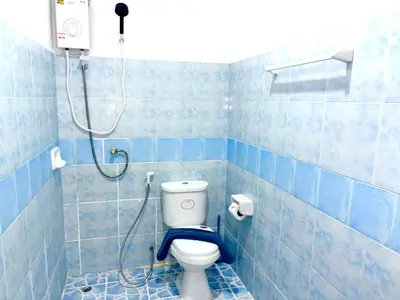 a blue tiled bathroom with a toilet and a shower at Patong Canal Villa 103 in Patong Beach