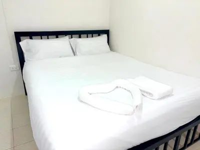 a bed with a pair of white shoes on it at Patong Canal Villa 103 in Patong Beach