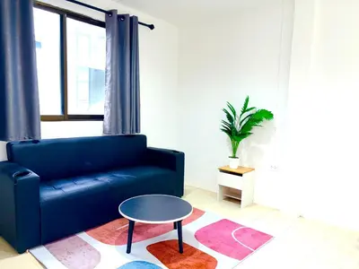 a living room with a blue couch and a table at Patong Canal Villa 304 in Patong Beach