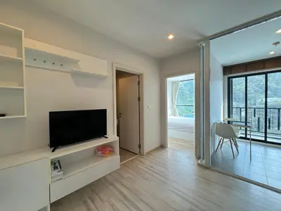 a living room with a flat screen tv sitting on a shelf at The Base Height Phuket in Phuket Town