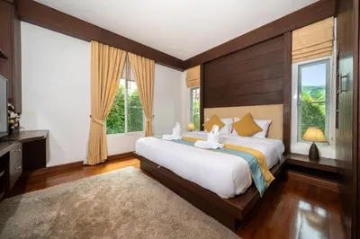 a bedroom with a large bed and two windows at Villa with Huge Private Pool and Tropical Garden Just 10 Minutes Walk to Kamala Beach in Kamala Beach