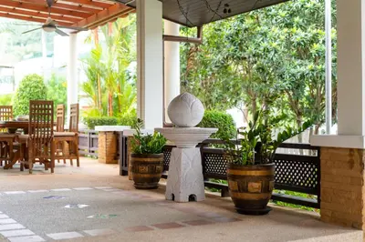 a porch with a statue and plants in pots at Villa with Huge Private Pool and Tropical Garden Just 10 Minutes Walk to Kamala Beach in Kamala Beach
