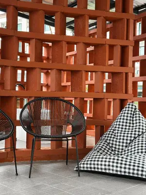 a chair and a blanket next to a wooden wall at Tiger Nest Stay in Ban Suan