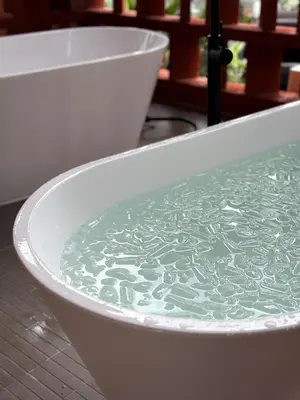 a bath tub filled with water in a bathroom at Tiger Nest Stay in Ban Suan