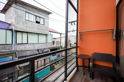 a balcony with a table and a building at Tiger Nest Stay in Ban Suan
