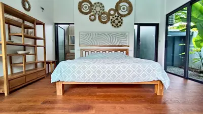 a bedroom with a bed in a room with windows at Sarang Jati Mansion in Ban Saiyuan (1)