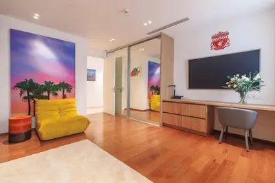 a living room with a yellow couch and a television at ANGSANA Coastal Bliss Penthouse 3bds Apartment with pool in Laguna Phuket
