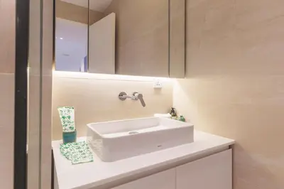 a bathroom with a white sink and a mirror at ANGSANA Coastal Bliss Penthouse 3bds Apartment with pool in Laguna Phuket