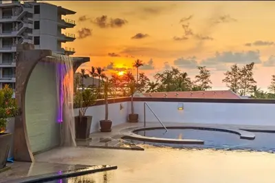 a pool on the roof of a building with a sunset at Studio Bangla Suite 304 in Patong Beach
