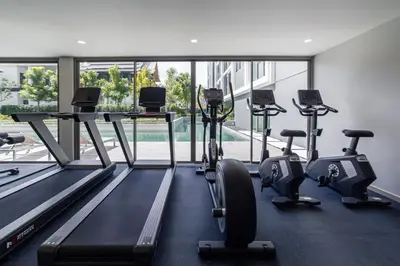 a gym with treadmills and exercise bikes in a building at Ozone Modern in Laguna Phuket