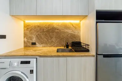 a kitchen with a sink and a washing machine at Ozone Modern in Laguna Phuket