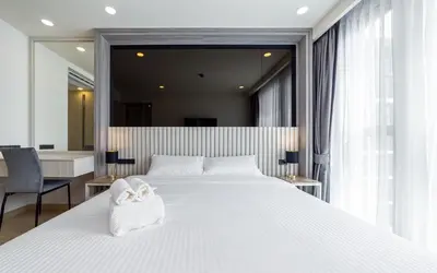 a bedroom with a large white bed with a white purse on it at Ozone Modern in Laguna Phuket