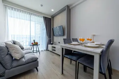 a living room with a table and a couch at Ozone Modern in Laguna Phuket