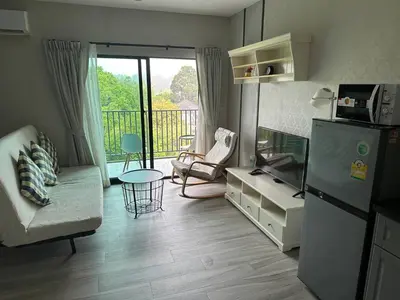 a living room with a refrigerator and a balcony at Апартаменты Пхукет in Phuket Town