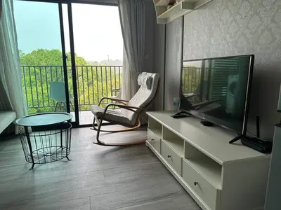 a living room with a television and a balcony at Апартаменты Пхукет in Phuket Town