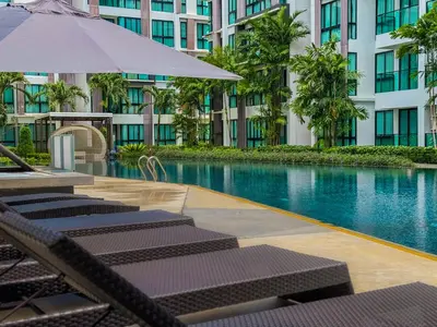 a hotel swimming pool with lounge chairs and an umbrella at Great 1Bdr Royal Lee Nayang beach in Ban Bo Han