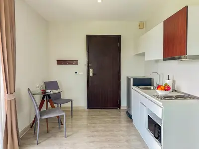 a small kitchen with a table and a door at Great 1Bdr Royal Lee Nayang beach in Ban Bo Han