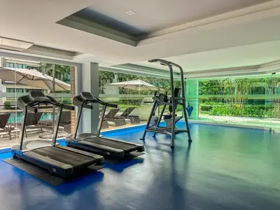 a gym with two treadmills and a swimming pool at Great 1Bdr Royal Lee Nayang beach in Ban Bo Han