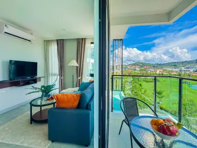 a room with a balcony with a table and a couch at Great 1Bdr Royal Lee Nayang beach in Ban Bo Han