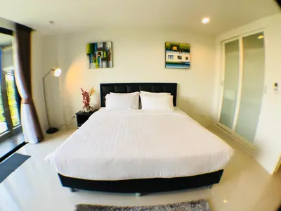 a bedroom with a large bed with white sheets at Seaview At Cape Panwa in Panwa Beach