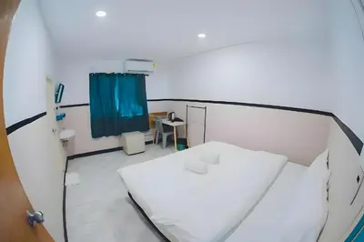 a hospital room with a white bed and a blue curtain at XX Mitr Inn Phuket Island - Phuket Old Town in Phuket Town