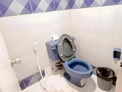 a blue toilet in a bathroom with purple and white tiles at XX Mitr Inn Phuket Island - Phuket Old Town in Phuket Town