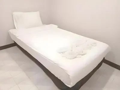 a white bed with white dishes on it at XX Mitr Inn Phuket Island - Phuket Old Town in Phuket Town