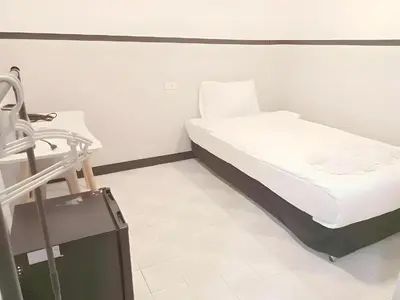 a bed in a hospital room with a suitcase at XX Mitr Inn Phuket Island - Phuket Old Town in Phuket Town