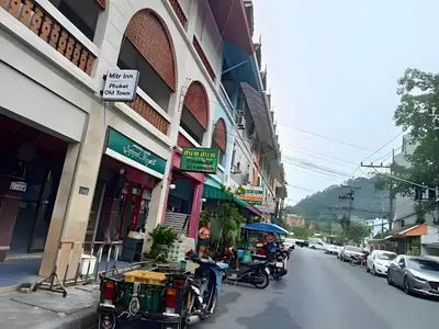a group of people sitting at tables on a city street at XX Mitr Inn Phuket Island - Phuket Old Town in Phuket Town