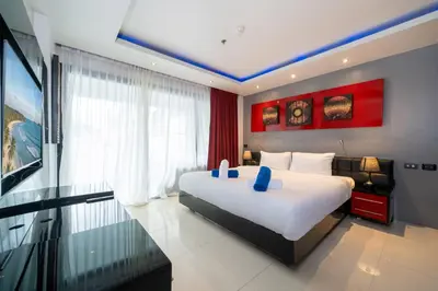 a bedroom with a large white bed and a window at Absolutely Amazing Bangla 1BR Suite in Patong Beach