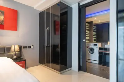 a bedroom with a sliding glass door leading to a bathroom at Absolutely Amazing Bangla 1BR Suite in Patong Beach