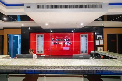 a woman sitting at a desk in a red wall at Absolutely Amazing Bangla 1BR Suite in Patong Beach