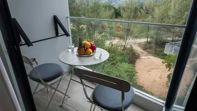 a table with a bowl of fruit on it in front of a window at Laya Resort - Forest View Studio in Layan Beach